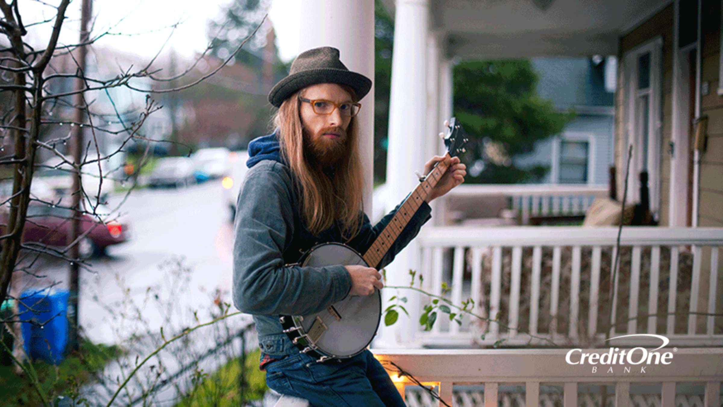 A man on the porch playing the banjo