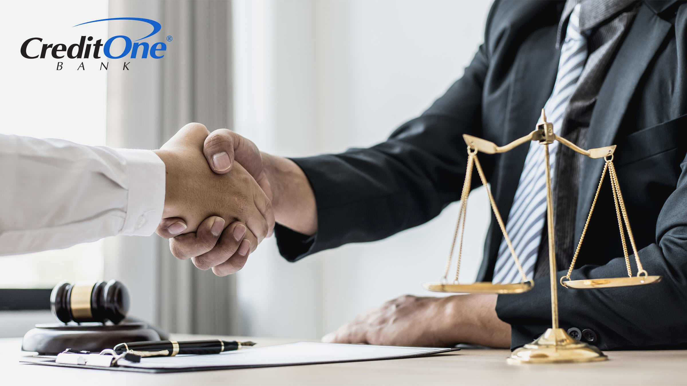 A lawyer and client shake hands over a legal desk, representing the act of applying for credit after bankruptcy.